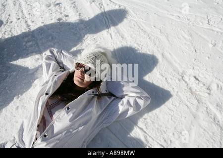 Woman in snowsuit resting on a ski slope Stock Photo