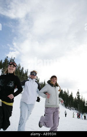Three women running down a ski slope Stock Photo