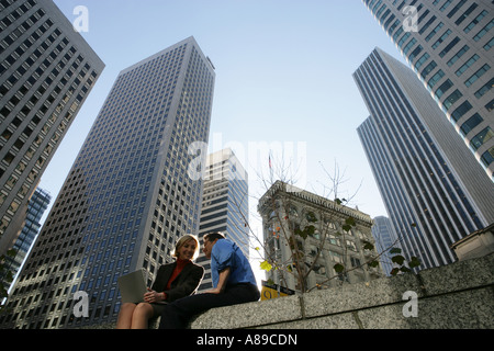 Two people talking outside with a laptop Stock Photo