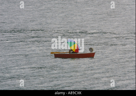 Angler with umbrella in red rowing boat on the Walchen lake, Upper Bavaria, Bavaria, Germany