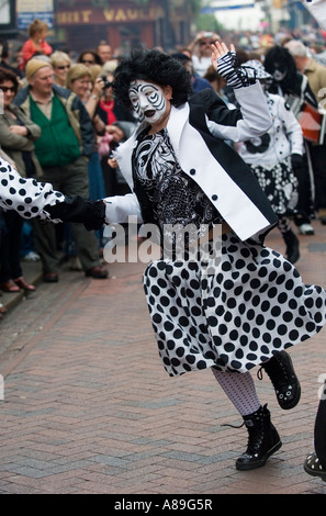 Woman wearing a black and white costume dancing in the street at Rochester Sweeps festival Stock Photo