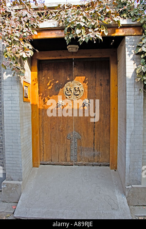 CHINA BEIJING Door into traditional hutong home with lion door knockers in one of the narrow alleyways crisscrossing Beijing Stock Photo