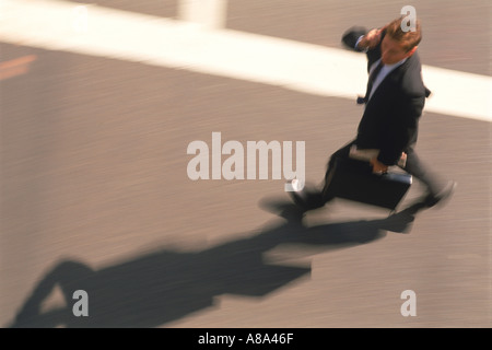Businessman with briefcase in crosswalk Stock Photo