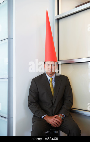 Businessman wearing dunce cap