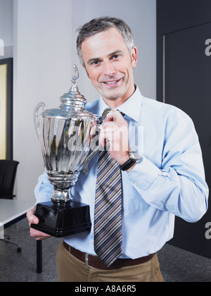 Businessman holding a trophy Stock Photo