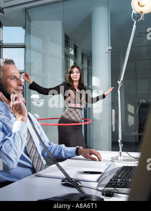 Office worker playing with hula hoop Stock Photo
