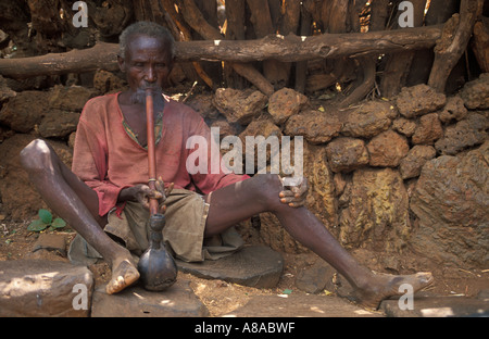 Konso man smoking a water pipe, Mecheke village, Konso region, Southern Ethiopia Stock Photo