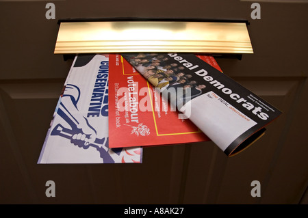 Labour conservative and Lib Dem election leaflets in a letterbox Stock Photo