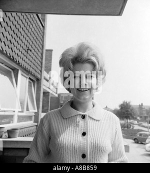 Black and white portrait of a young woman from 1969 with blonde hair and a cheerful smile Stock Photo