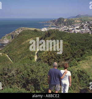 Couple looking at view east over Ilfracombe the coastline and sea from bush covered hills of Torrs Park Devon England Stock Photo