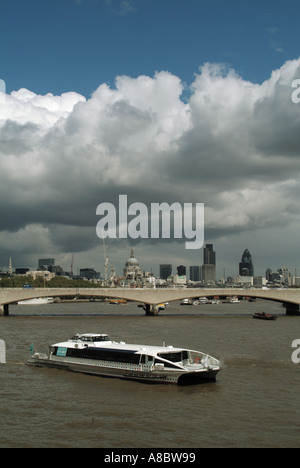 River Thames Waterloo Bridge and tour boat with big sky over City of London skyline Stock Photo