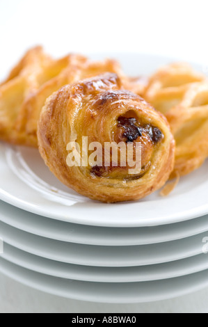Small danish pastries on stack of white plates Stock Photo