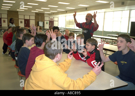 Charismatic teacher leading students in song during class. Golden Valley Minnesota USA Stock Photo