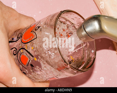 Running Water into a Glass from a Tap Stock Photo