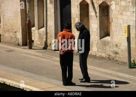 Men chatting at railway station Stock Photo