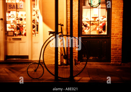 Old time one seat bicycle at storefront in New Orleans at night Stock Photo