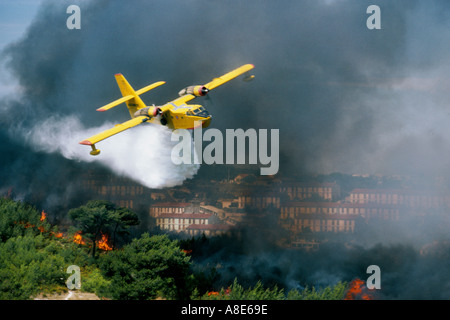 Aerial view of a Canadair firefighting water bomber airplane dousing water over a wildfire near the city of Marseille, Provence, France, Europe, Stock Photo
