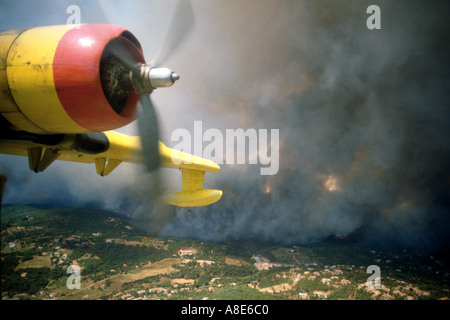 Canadair firefighting water bomber airplane's engine and aerial view of a wildfire with dense forest fire smoke cloud, Provence, France, Europe, Stock Photo
