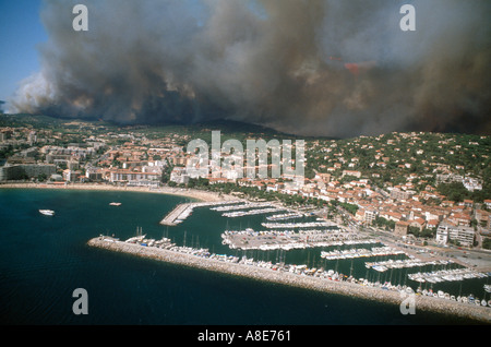 Aerial view of Sainte-Maxime bay with harbour and town, wildfire on foothills, forest fire clouds of smoke, Var, Provence, France, Europe, Stock Photo