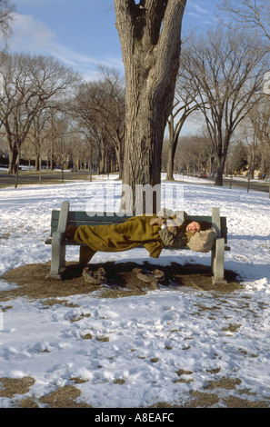 50 yr old homeless man sleeping on park bench. St Paul Minnesota USA Stock Photo