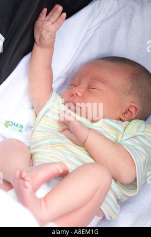 Newborn baby raising her hand like she tries to call someone s attention Stock Photo