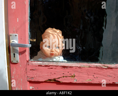 Doll Behind Glass Door Stock Photo