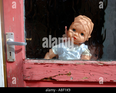 Doll Behind Glass Door Stock Photo