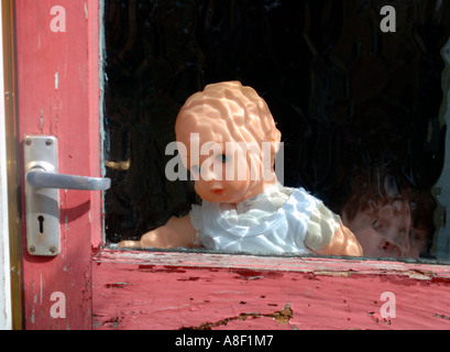 Doll Behind Glass Door Stock Photo