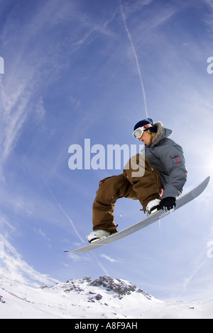 Snowboarder mid air grabs board. Stock Photo