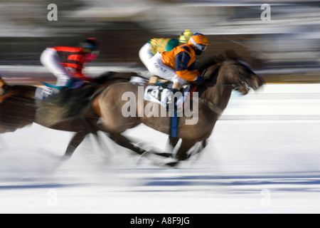 Three jockeys flat out toward the finishing post on the icy frozen lake at the 'White Turf' meeting, St Moritz, Switzerland. Stock Photo