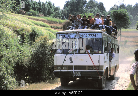 Overcrowded transport with people sitting on top of the local bus in Kathmandu valley Nepal Stock Photo