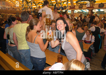 Europe Germany Munich Beer Festival Oktoberfest people dancing and drinking in tent hall and partying. Stock Photo
