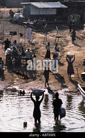 Women and children collect water from Lake Volta, Ghana, West Africa. Stock Photo