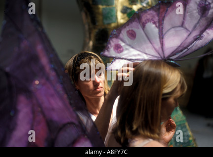 a costume maker adjusts a fantasy costume on a model Stock Photo