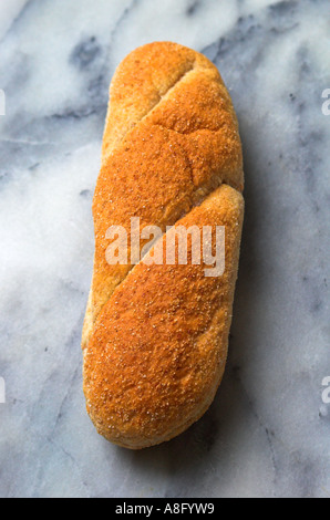 A wholemeal submarine roll on a marble background Stock Photo