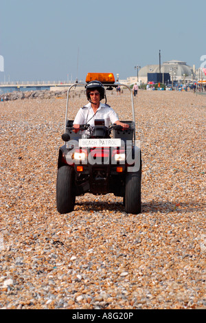 Police officer on quad bike patrolling Worthing, West Sussex beach. UK Stock Photo