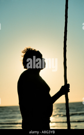 aboriginal with walking stick gazing at the sea, Darwin, Australia Stock Photo