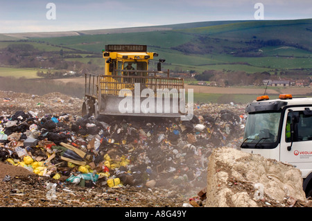 A busy landfill site in action with dustcarts refuse trucks and bulldozers. Beddingham, South East UK. Stock Photo