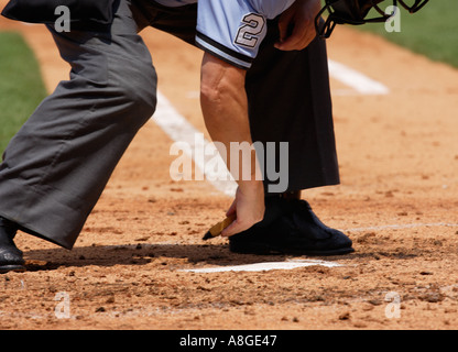 A baseball umpire cleaning home plate Stock Photo