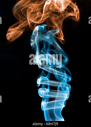 Colorized incense smoke trails on a black background Stock Photo