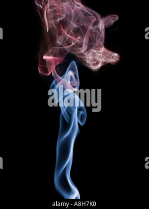 Colorized incense smoke trails on a black background Stock Photo