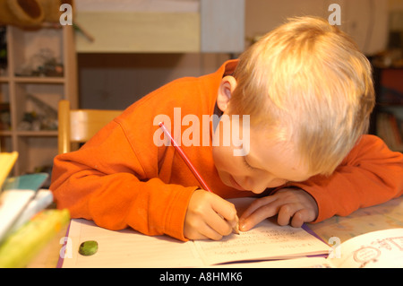 Seven year old boy is doing his homework Stock Photo