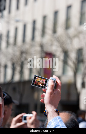 Tourist photographing w at NYC Easter Parade on 5th Avenue USA Stock Photo