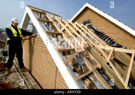 Trainee bricklayer completes a wall on a new housing estate. Stock Photo