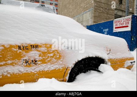 A yellow cab is parked on a snow covered street in Harlem after a blizzard in New York City USA February 2006 Stock Photo
