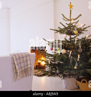 Decorated Christmas tree by open fireplace Stock Photo