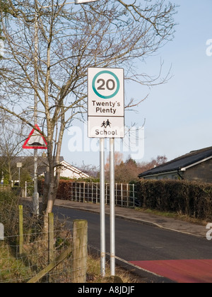 Twenty miles per hour speed limit sign and traffic calming scheme with Twenty's Plenty slogan by a school. Scotland, UK, Britain Stock Photo