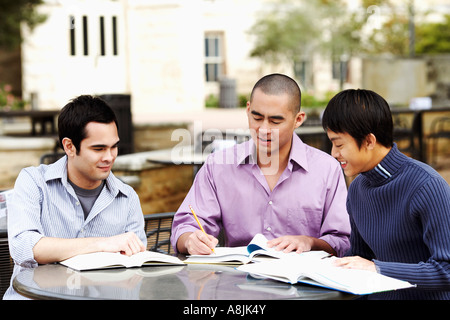 Three young men studying in a college campus and smiling Stock Photo
