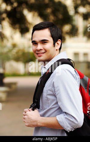 Portrait of a young man carrying a backpack and smiling Stock Photo