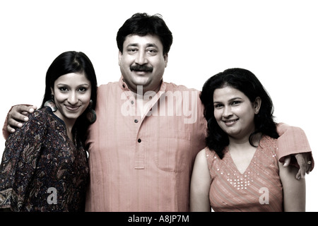 Portrait of a mature man smiling with a young woman and a mid adult woman Stock Photo